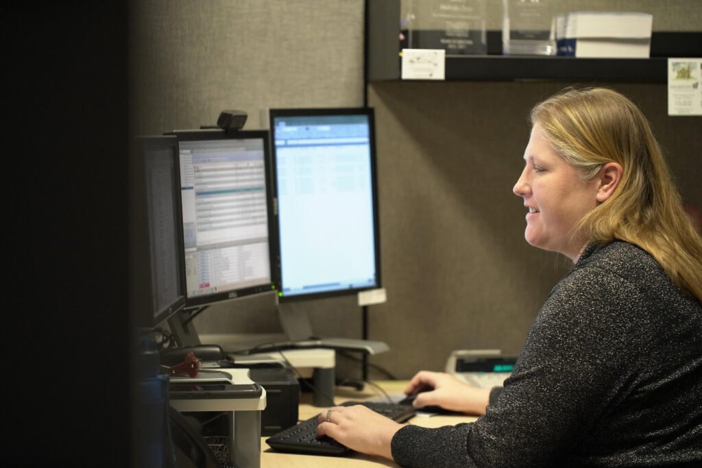 Atchley & Associates team member working at a desk with two computer monitors