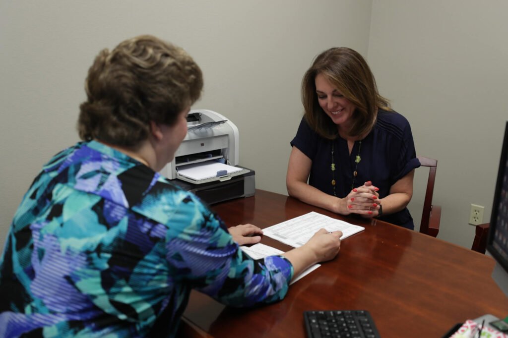Two people reviewing documents across a desk at Atchley & Associates